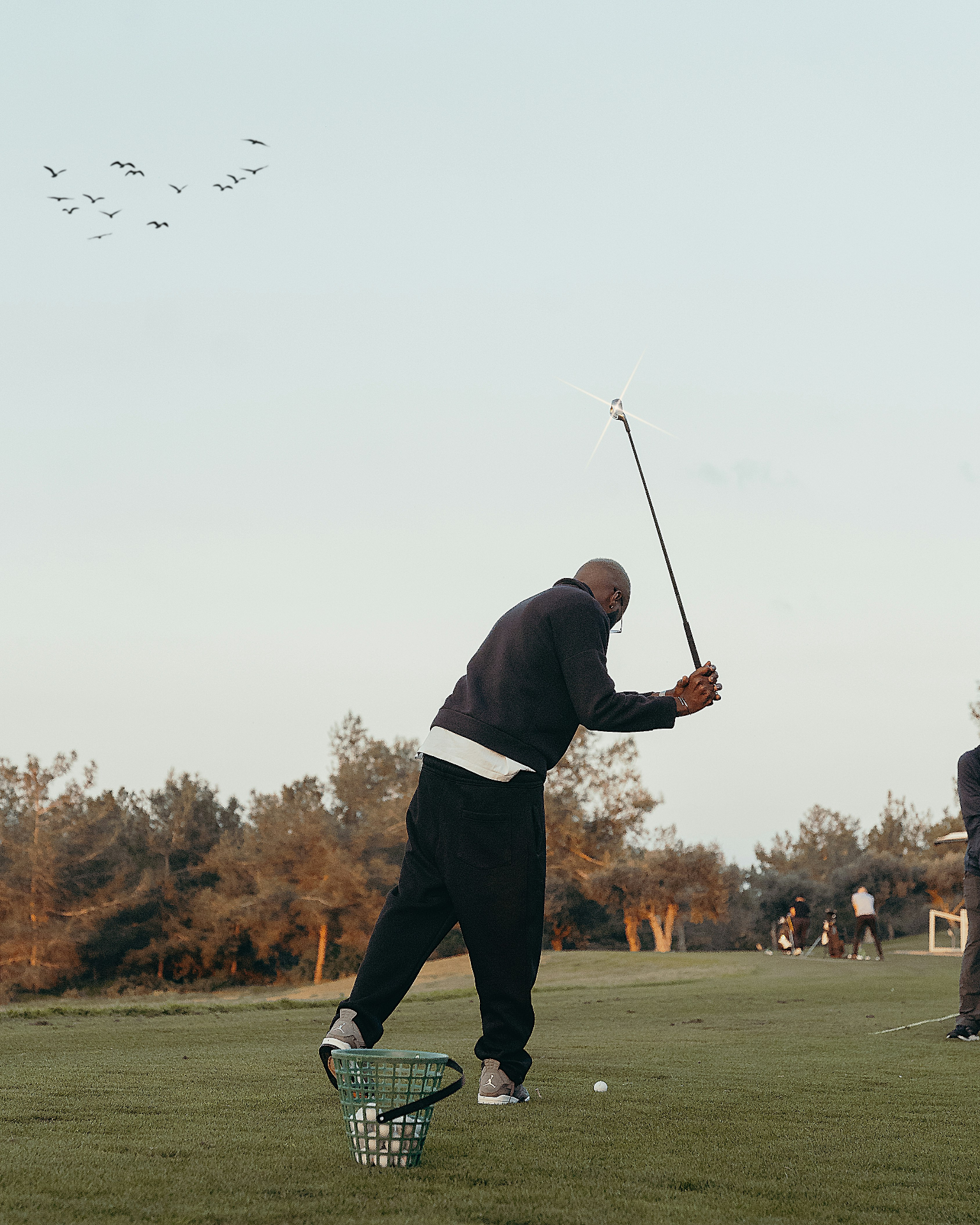 Golfer at the driving range at dusk